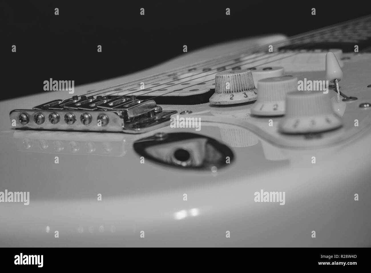 Bianco nero la musica rock concetto, solo filo elettrico chitarra con ponte, stringhe, del controllo di volume e di tono, rilevatori, jack di ingresso Foto Stock