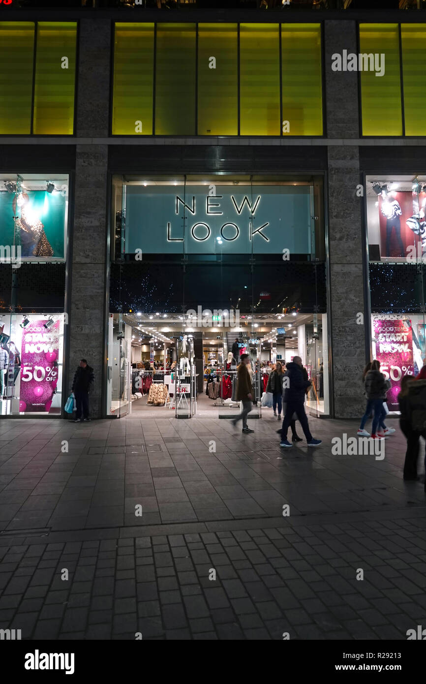 Persone in silhouette camminare davanti a un nuovo look store in Liverpool One Shopping Complex di notte. Liverpool Regno Unito. Novembre 2018. Foto Stock