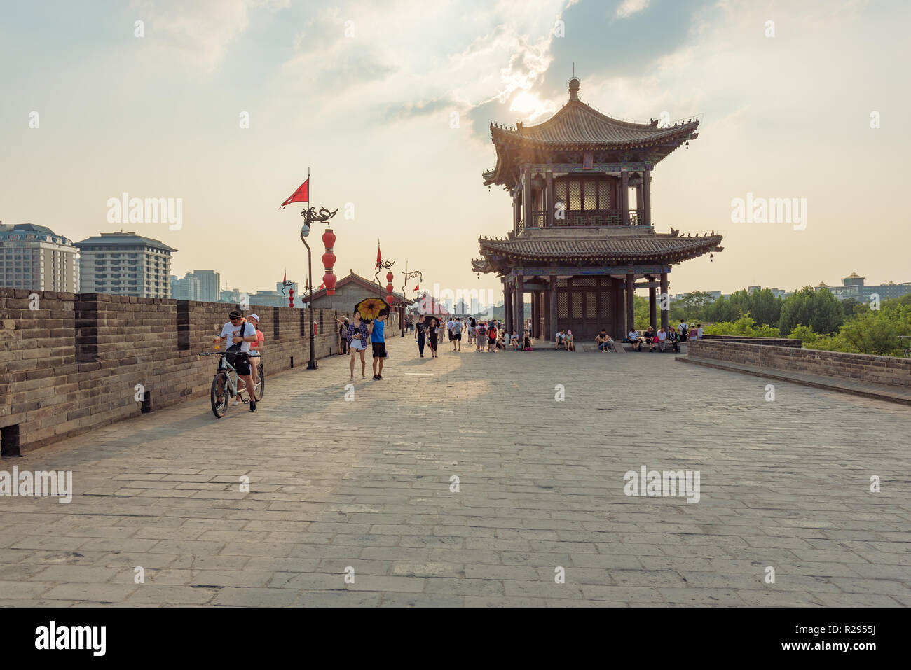 Xi'an, Shaanxi Province, Cina - 8 Agosto 2018 : la gente a piedi e in bicicletta equitazione sulla città fortificata nel muro tardo pomeriggio Foto Stock