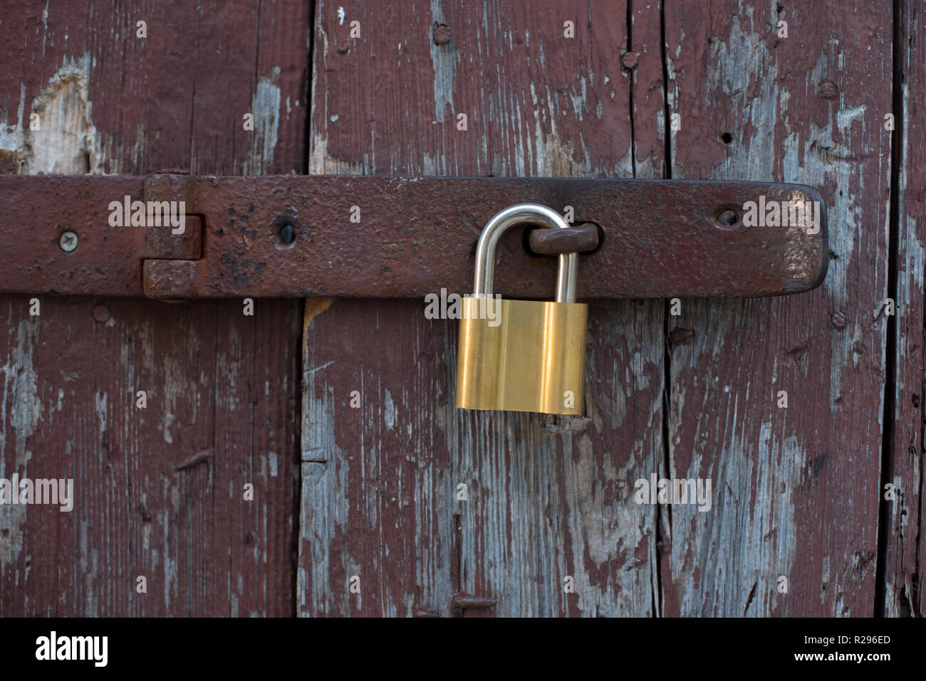 Vecchie porte in legno bloccato con metallo blocco giallo. Nuovo blocco giallo su vecchie porte marrone. Foto Stock