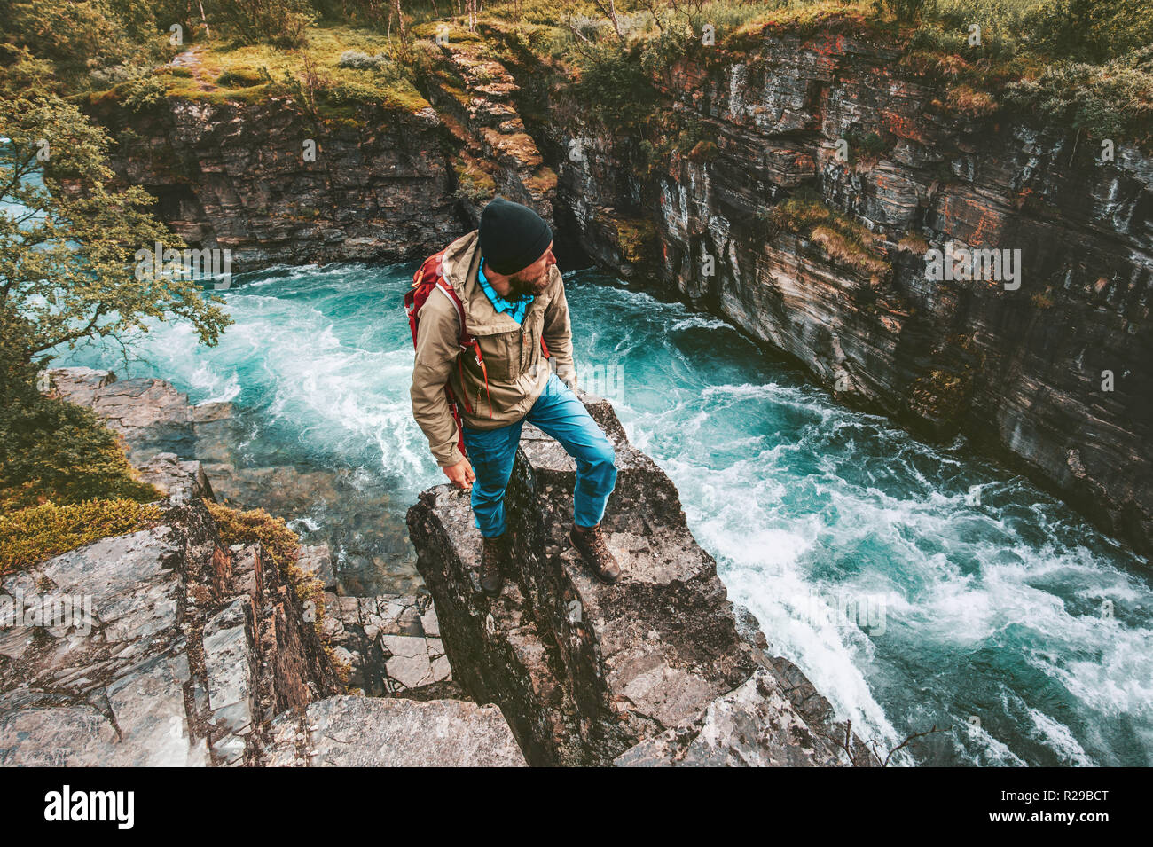 Adventurer uomo escursionismo da solo uno stile di vita attivo vacanze estreme outdoor sulla rupe sopra river canyon in Svezia Foto Stock