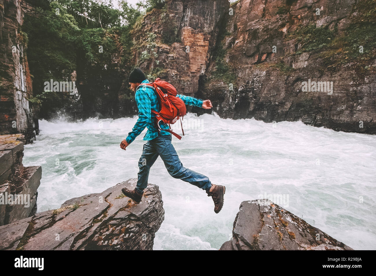 Running Man avventura di viaggio vacanze attive su uno stile di vita sano endurance sport estremo concetto backpacker salto sulla rupe sopra il fiume canyon Foto Stock