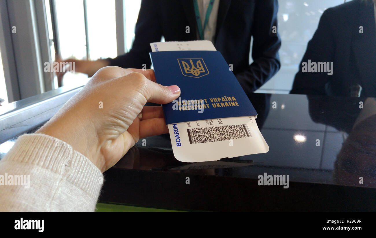 Il controllo doganale. Donna ucraina di consegnare il passaporto e biglietto per il funzionario doganale. Il check-in in aeroporto. Carta d'imbarco all'interno del passaporto. Foto Stock