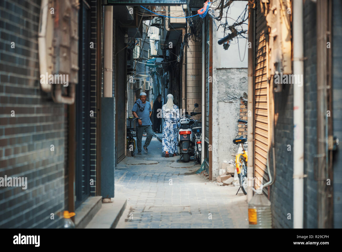 Xi'an, Shaanxi Province, Cina - 14 Ago, 2018 : Cinese persone islamica in una strada stretta del Xi'an quartiere islamico Foto Stock