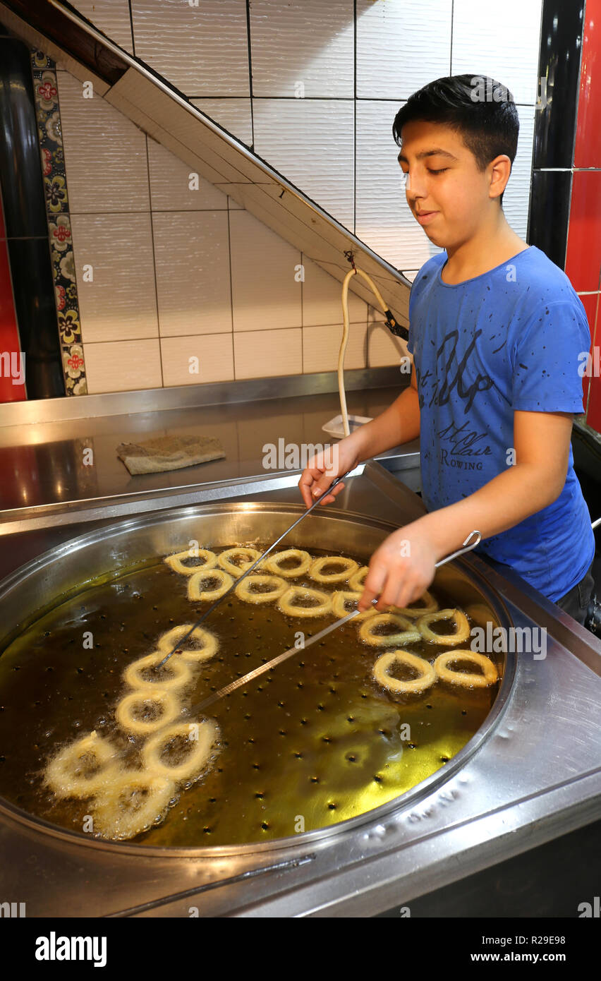 ADANA, Turchia-ottobre 23:Unidentified giovane ragazzo turco di frittura Churro Halka Tatli al dessert Shop.Ottobre 23,2018 di Adana, Turchia. Foto Stock
