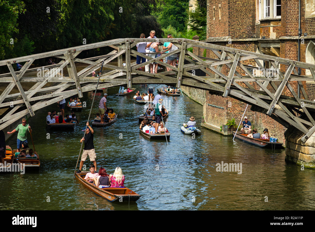 La famosa e matematici storico ponte di legno con persone che camminano su di esso come punt barche di passare al di sotto di su una soleggiata giornata estiva, Cambridge, Regno Unito Foto Stock