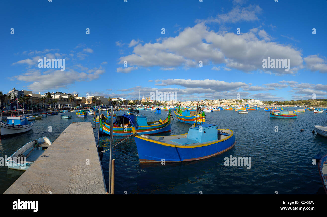 Il villaggio di Marsaxlokk porta sull'isola mediterranea di Malta con le tradizionali imbarcazioni locali. Foto Stock