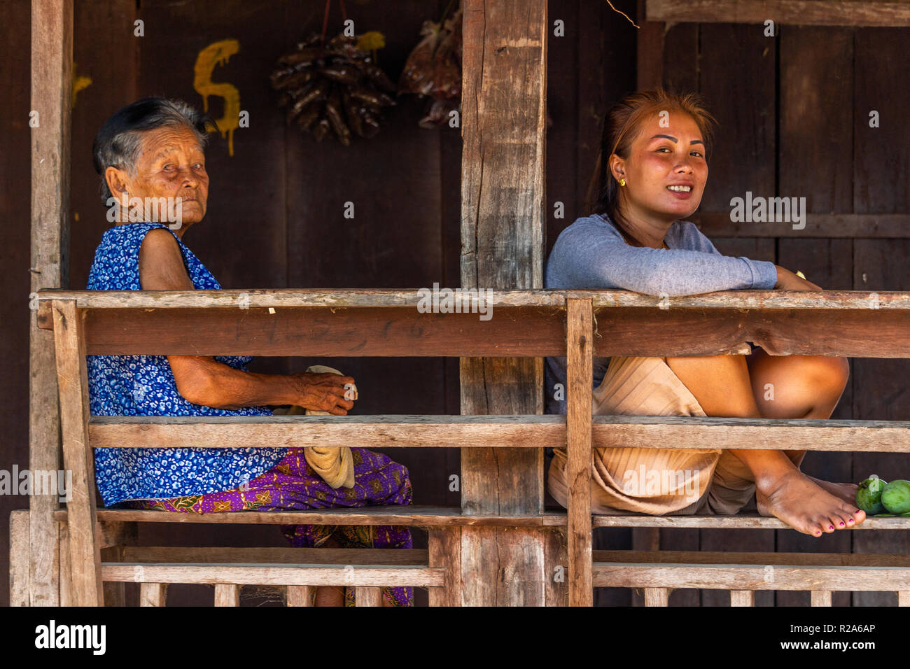 Don Det, Laos - Aprile 24, 2018: Le donne siedono all'ombra della terrazza di fronte a una casa in legno in un remoto villaggio del Laos Foto Stock