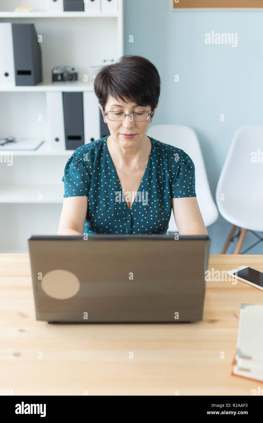 La gente di affari e il concetto di tecnologia - persone di mezza età business donna lavora su computer portatile nel suo ufficio Foto Stock