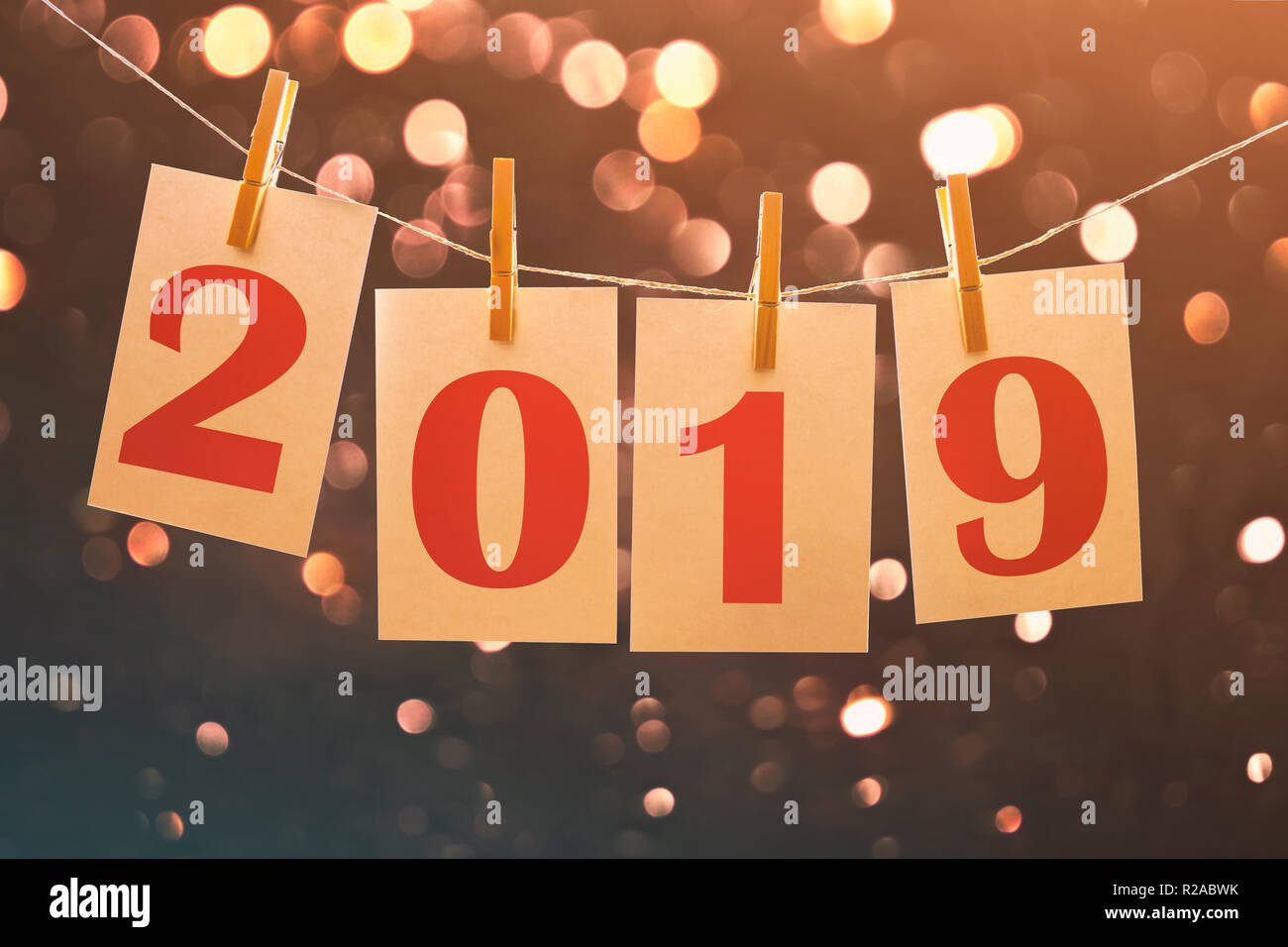 2019 Nuovo anno le schede di carta appeso su una stringa con luci sfocate in background Foto Stock