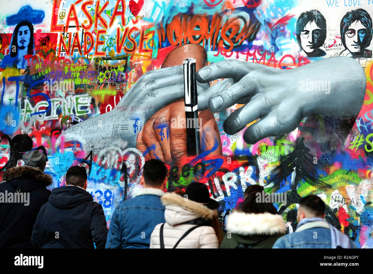 Praga, Repubblica Ceca. Xviii Nov, 2018. Il fenomeno del Muro di John Lennon a Praga è una calamita per i turisti. Nel quartiere di Mala Strana, vicino all'ambasciata francese, potrai vedere il Muro di John Lennon. Il muro che era precedentemente noto come una normale parete in Praga è stato chiamato LennonÃ Â's sin dagli anni ottanta, quando le persone hanno riempito con John Lennon-ispirato graffiti e pezzi di testi di canzoni dei Beatles. Il muro di Lennon rappresentava non solo un monumento a John Lennon e le sue idee per la pace ma anche un monumento alla libertà di parola e il non-violenta ribellione della Ceca Youth contro il regime. È stata una piccola guerra o Foto Stock