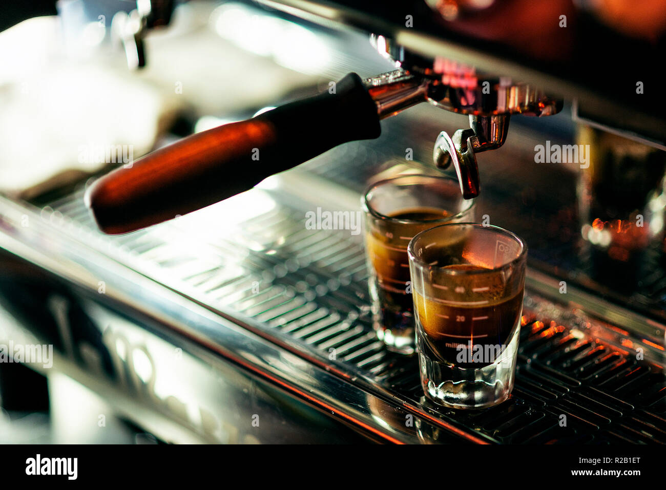 La preparazione di caffè espresso close up dettaglio con caffetteria moderna macchina e bicchieri Foto Stock