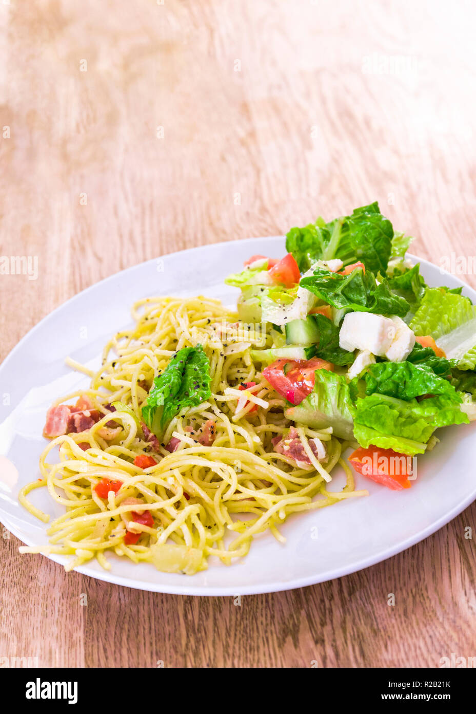 Appetitosa e aspetto fresco spaghetti alla carbonara pasta cena con insalata di mozzarella sul lato Foto Stock