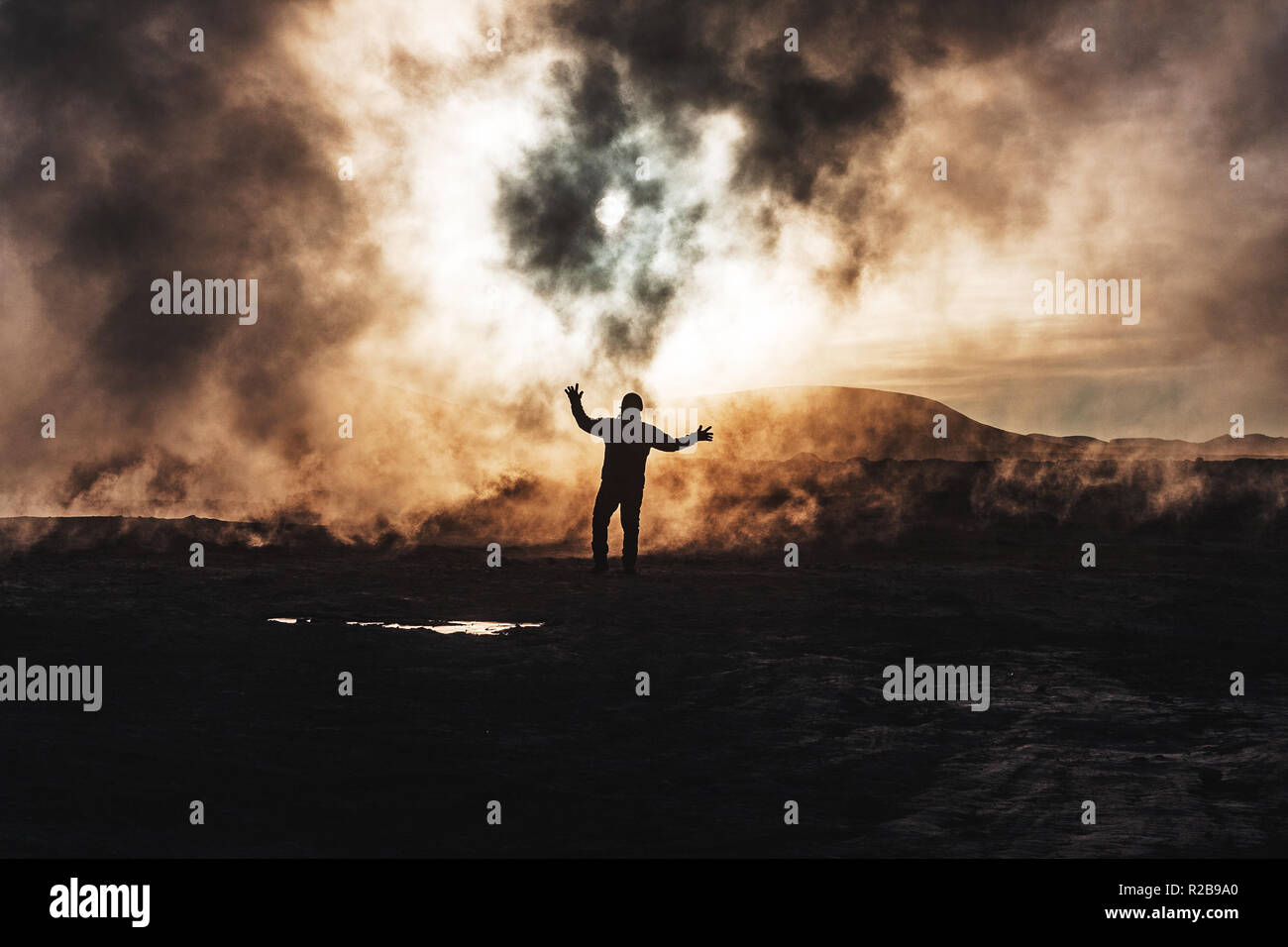 Silhouette di un uomo nella nebbia a sunrise nel geyser di Sol de Mañana, Bolivia Foto Stock