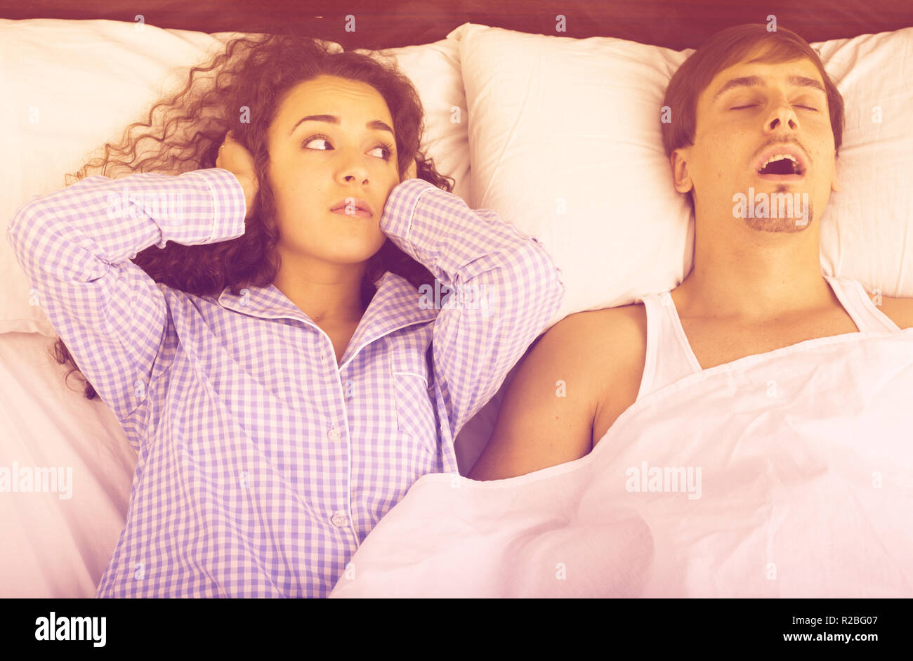 Fidanzato snorring e arrabbiato donna giaceva a letto sveglio Foto Stock