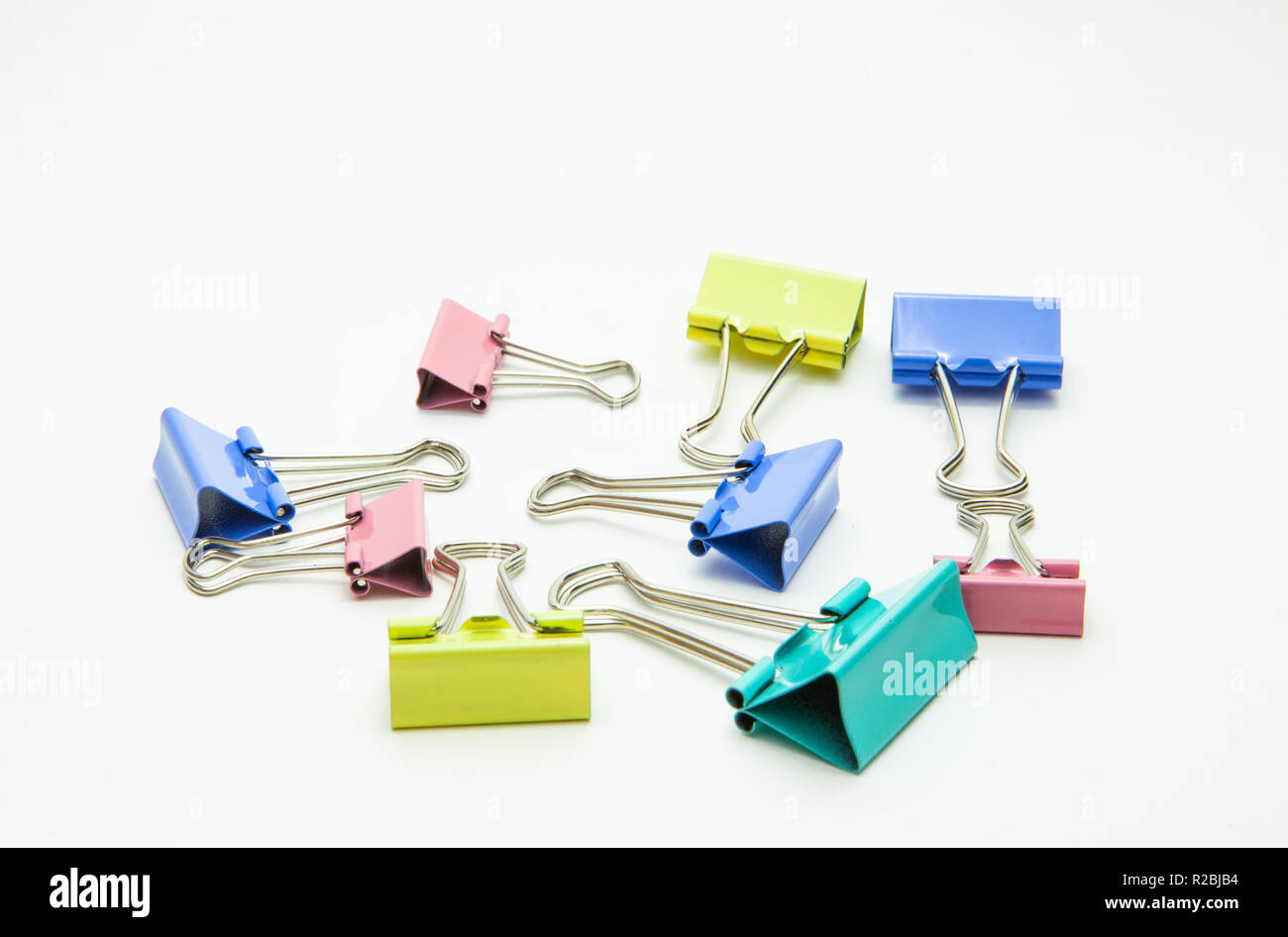Carta colorata clip sparsi su sfondo bianco Foto Stock