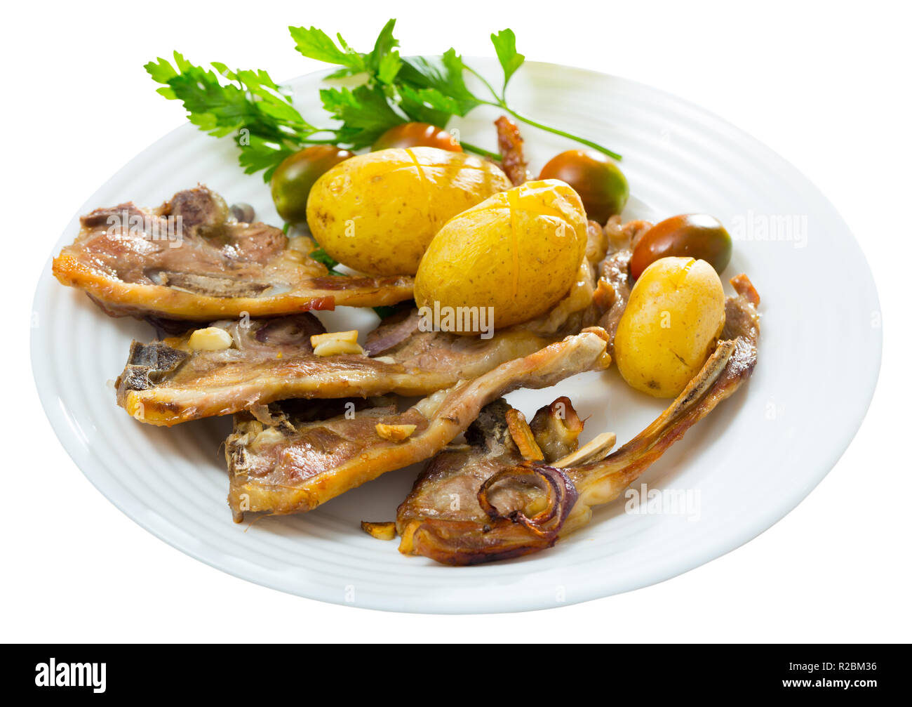 Tradizionale piatto spagnolo Costillas de cordero, agnello con verdure. Isolato su sfondo bianco Foto Stock