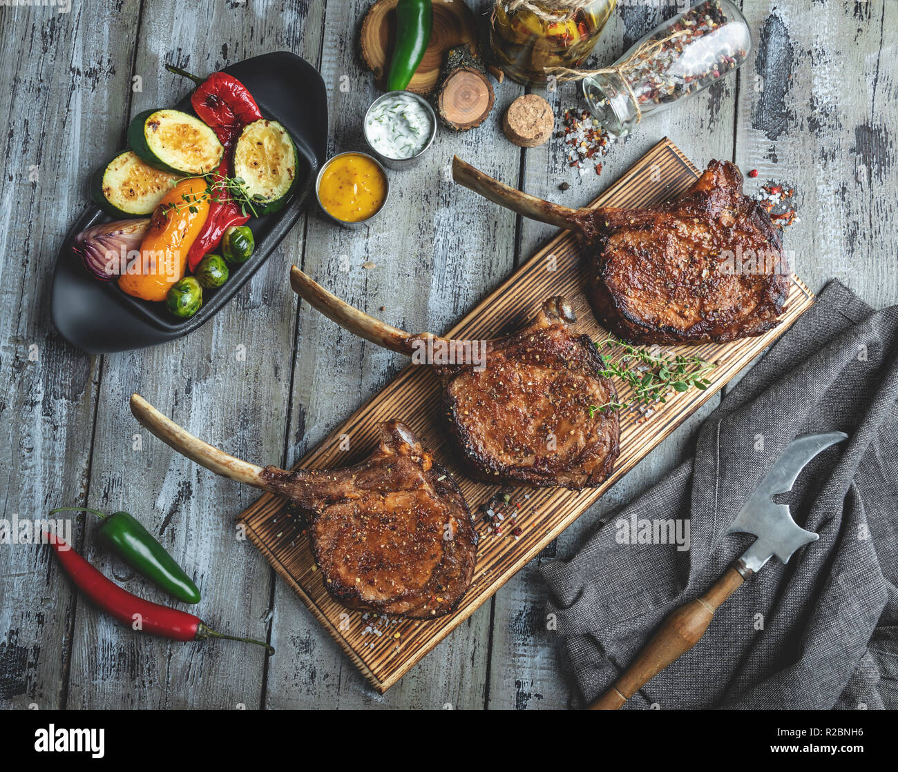 Agnello alla griglia,montone costolette di carne con verdure su una scheda che serve. Rustico concetto alimentare Foto Stock