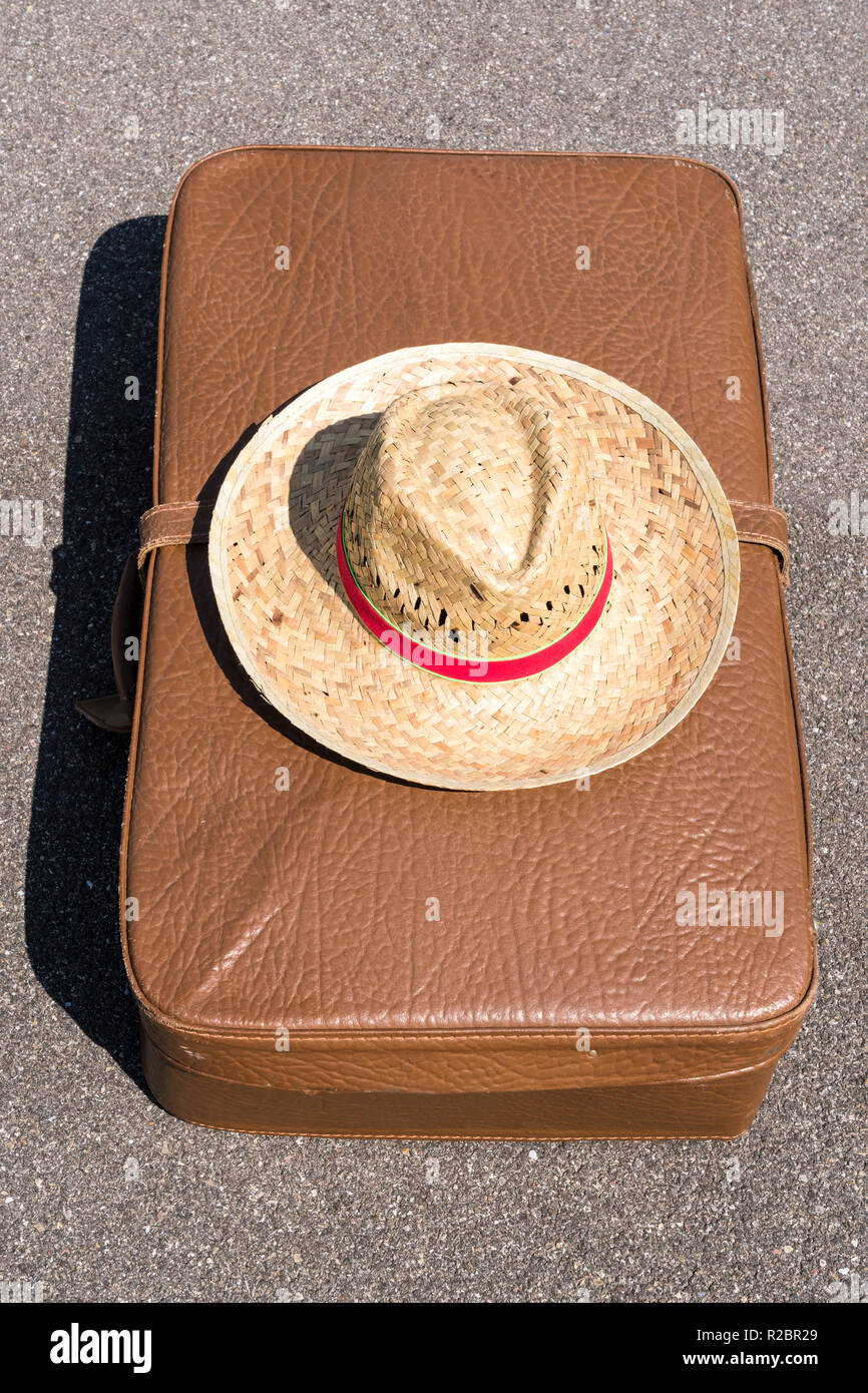 Vecchia valigia in pelle con cappello per il sole e la mappa Foto Stock