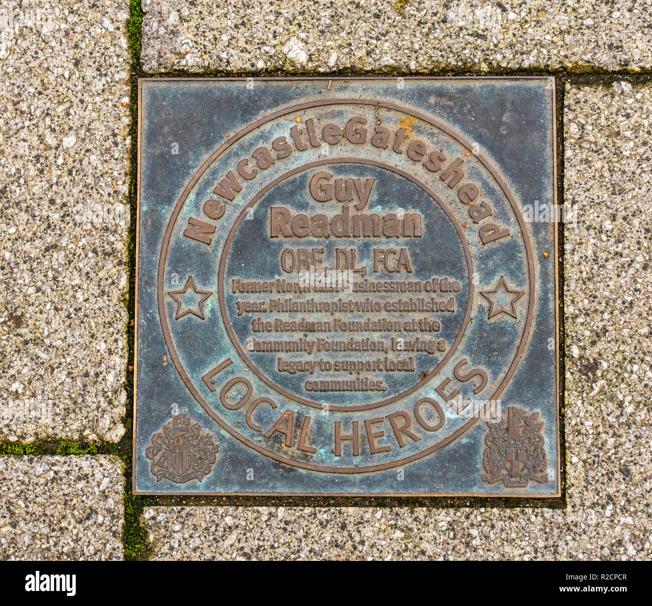 Targa di bronzo in onore di Newcastle Gateshead e ispirare le persone di 60 anni passati, Guy Readman, Quayside. Newcastle Upon Tyne, England, Regno Unito Foto Stock