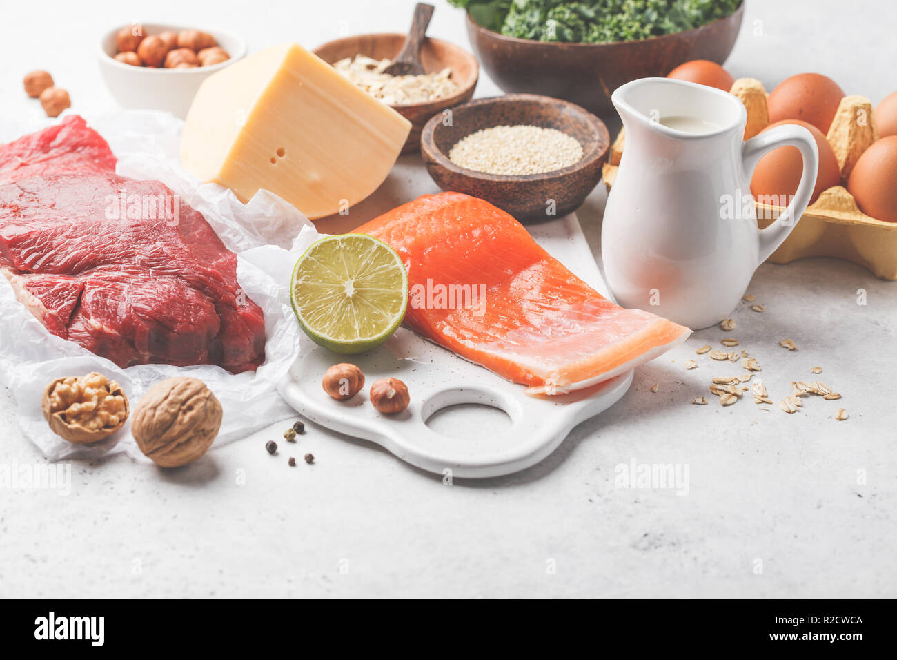 Dieta bilanciata cibo sfondo. Alimenti proteici: pesce, carne, uova, formaggio, quinoa, dadi su sfondo bianco, copia dello spazio. Foto Stock Dieta bilanciata cibo sfondo. Alimenti proteici: pesce, carne, uova, formaggio, quinoa, dadi su sfondo bianco, copia dello spazio. Foto Stock