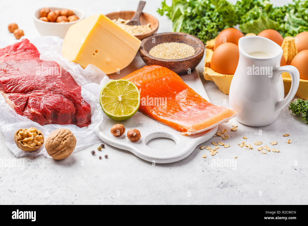 Dieta bilanciata cibo sfondo. Alimenti proteici: pesce, carne, uova, formaggio, quinoa, dadi su sfondo bianco, copia dello spazio. Foto Stock Dieta bilanciata cibo sfondo. Alimenti proteici: pesce, carne, uova, formaggio, quinoa, dadi su sfondo bianco, copia dello spazio. Foto Stock