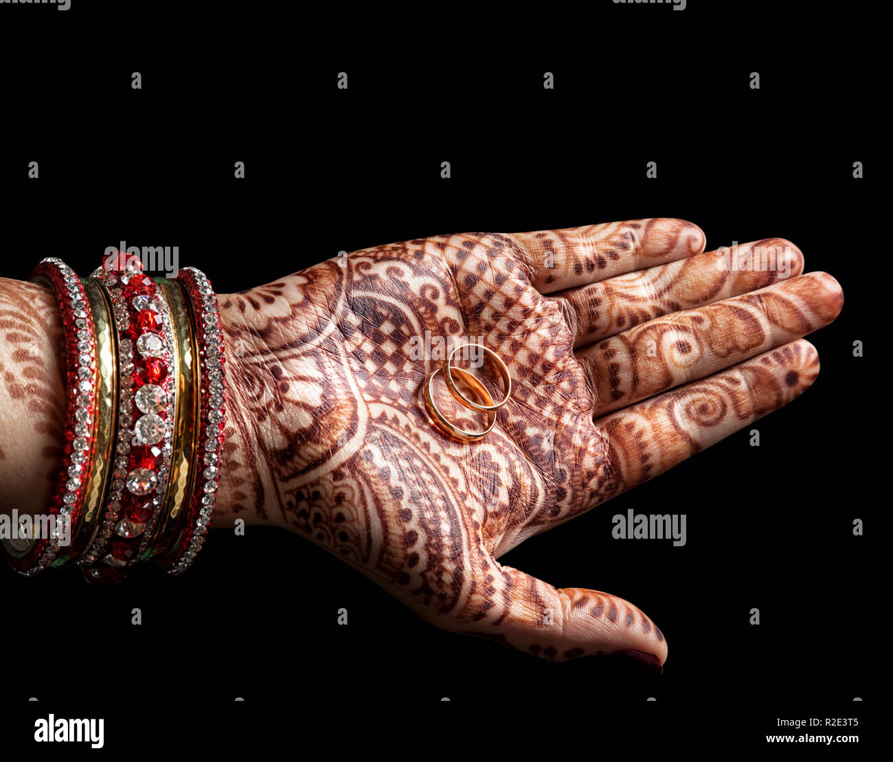 Gli anelli di nozze nella donna palm con henna dipinto su sfondo nero Foto Stock