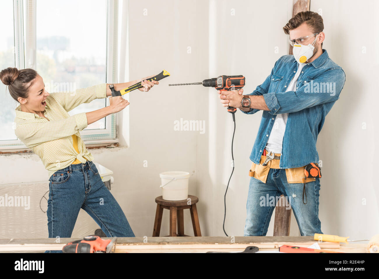 Felice coppia giovane divertendosi con strumenti durante il miglioramento di casa Foto Stock