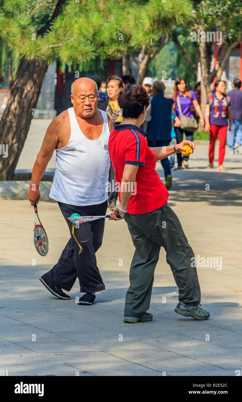 Pechino, Cina - 20 Settembre 2013: Elder matura la riproduzione di gioco cinese di Jianzi con un coloratissimo volano in piuma e un racket in Parco Beihai su un Foto Stock