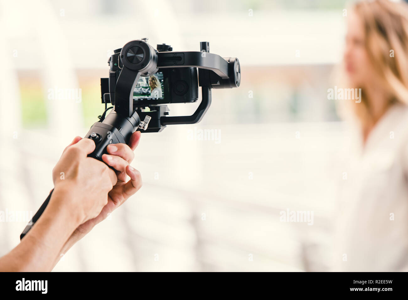 Sospensione cardanica motorizzato, videografo utilizzando la fotocamera reflex digitale anti shake strumento stabilizzatore per registrare video scena. Foto Stock