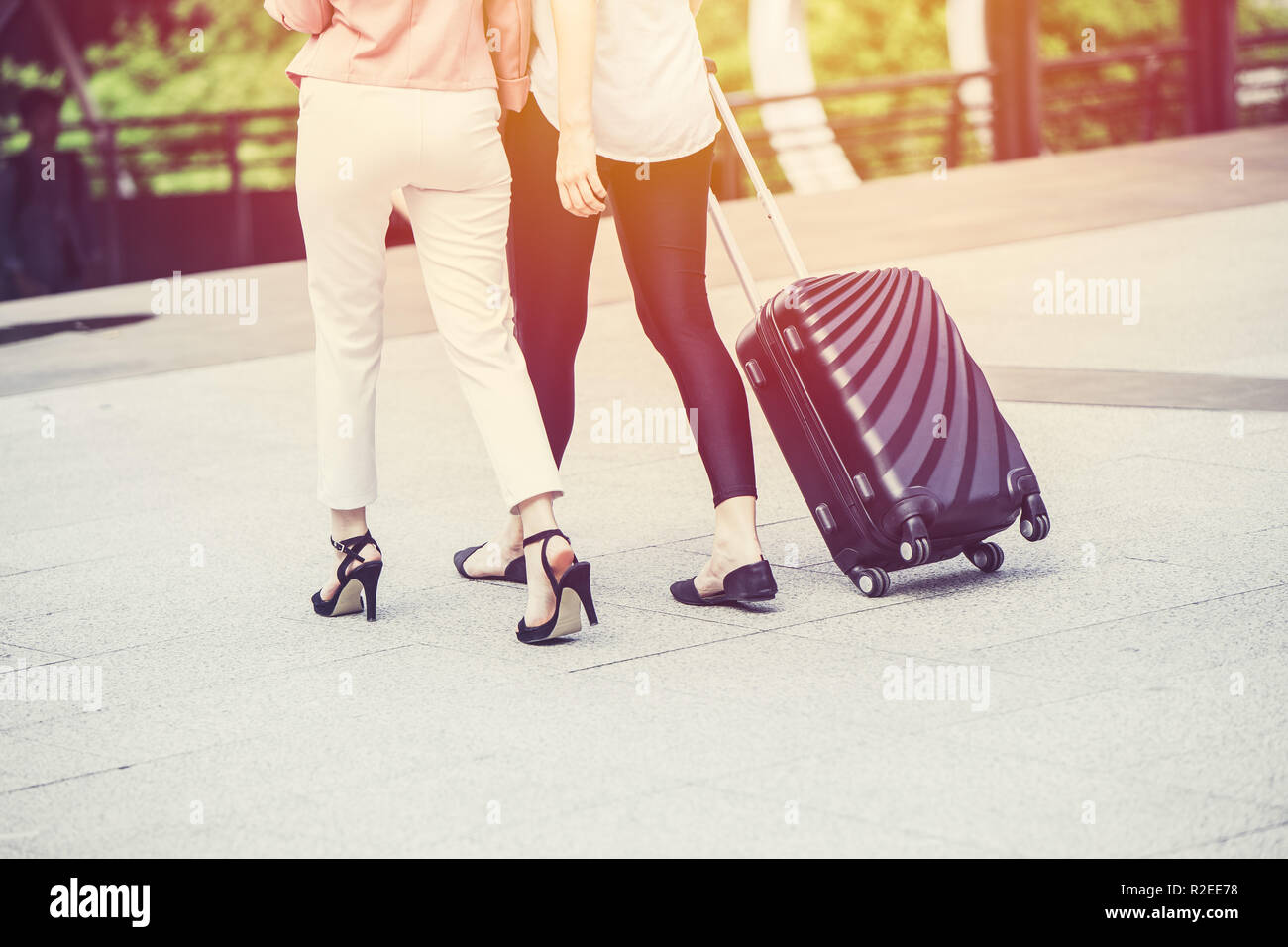 Gli amici di moda tacco alto ragazza turistica con bagagli il viaggiatore a piedi. Foto Stock