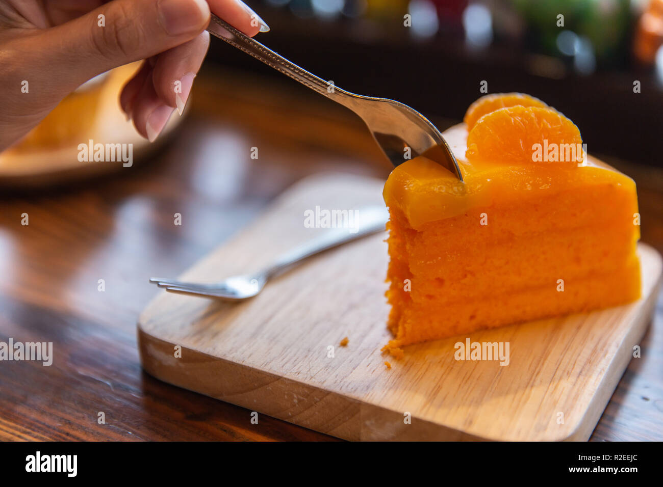 Arancione di mangiare la torta su un tavolo di legno. Delizioso dolce torta alla frutta. Foto Stock