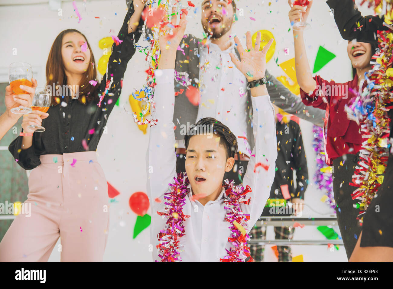 Felice anno nuovo partito colorato in office business persone divertimento insieme mix di gara. Foto Stock