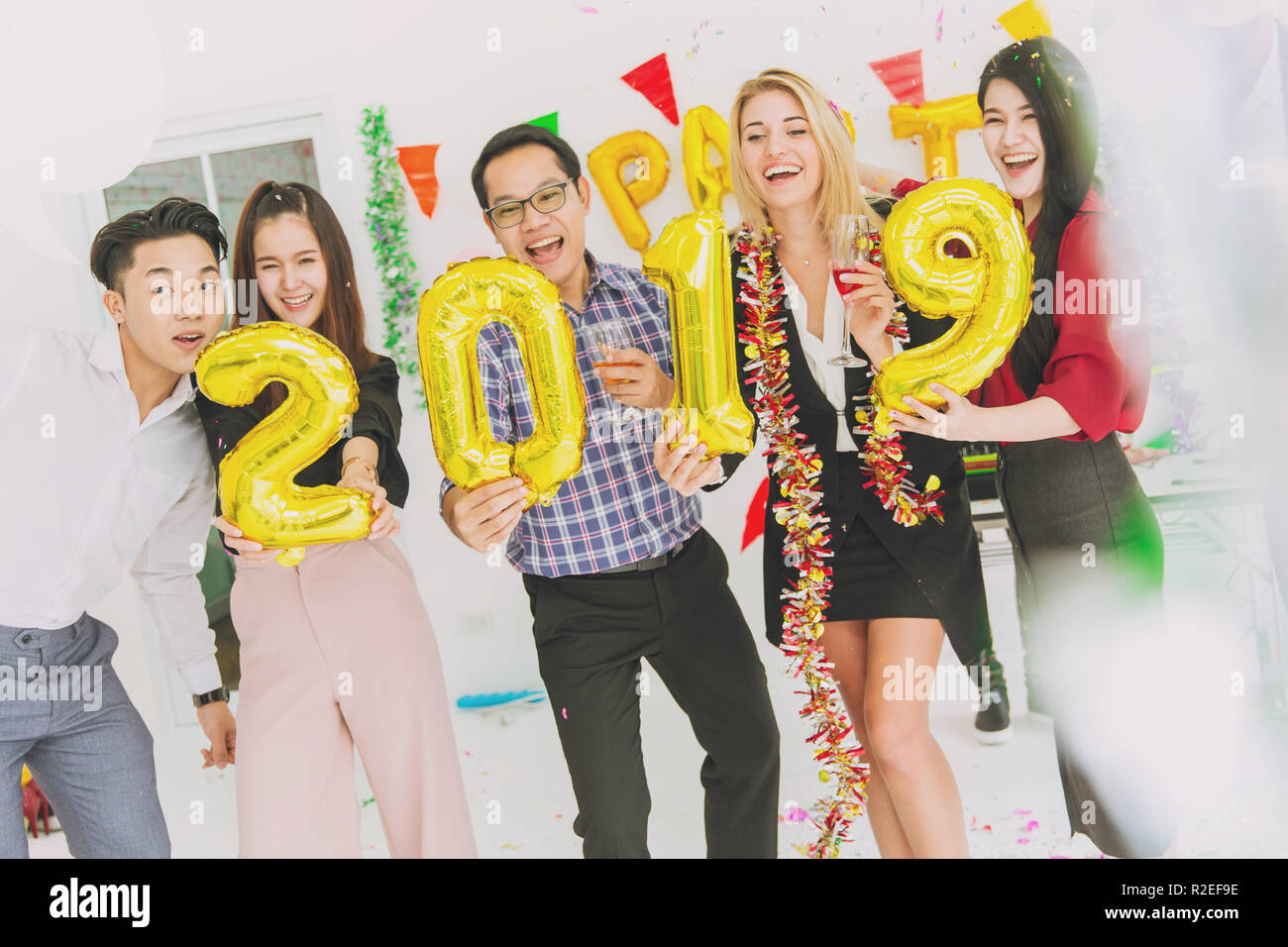 Felice anno nuovo partito colorato in office business persone divertimento insieme mix di gara. Foto Stock