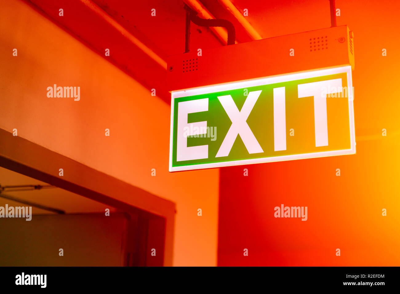 Green fire exit segno della luce di emergenza sportello di escape Foto Stock