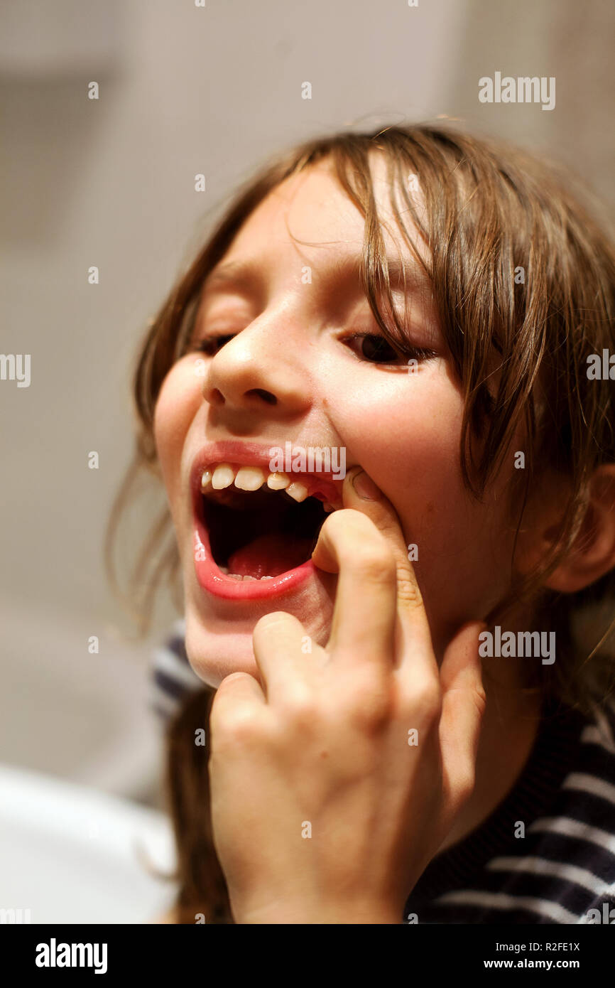 9 anno vecchio ragazzo ispezionando un dente mancante. Foto Stock