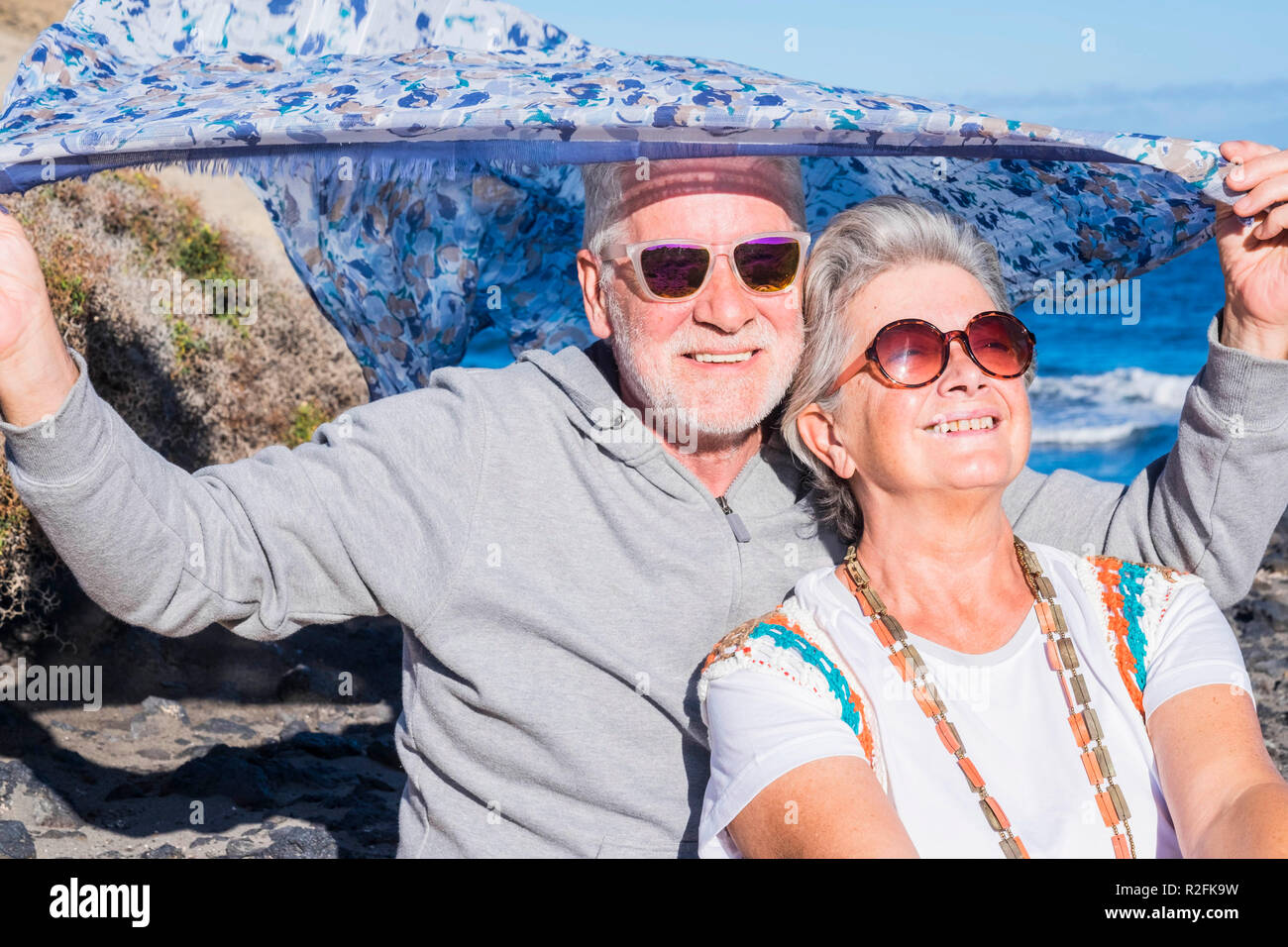 Nizza uomo e donna adulto sorriso senior e godersi il sole durante le vacanze estive o ritirato nuova vita in Tenerife. Grande soleggiata per uno stile di vita per sempre tempo di vacanza. hippy stile di libertà Foto Stock