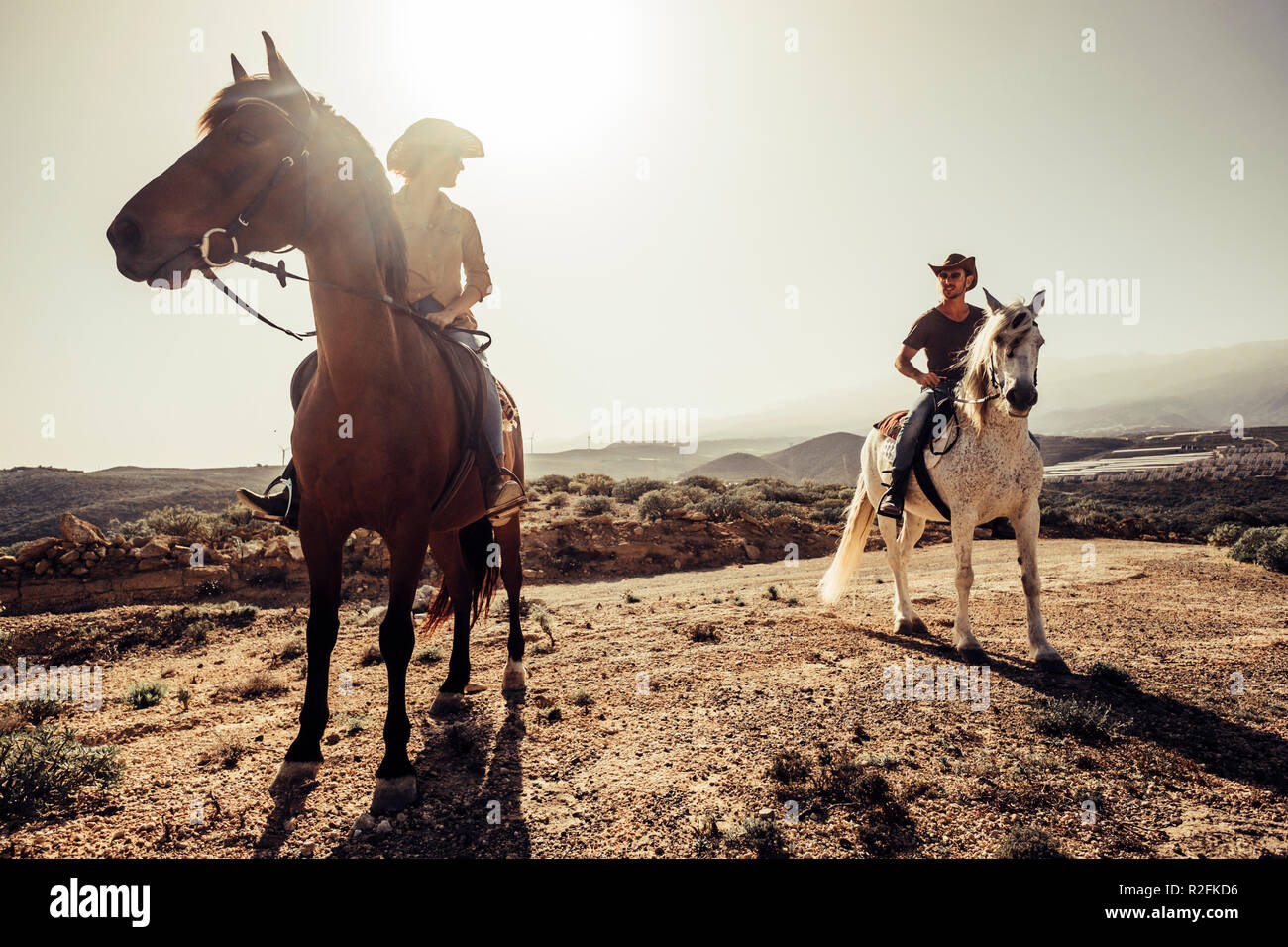 Coppia di cavalli e cowboy maschio e femmina ride free nella natura sulle montagne di Tenerife. Lo stile di vita e opere alternative o attività di svago di concetto per uomo e donna Foto Stock