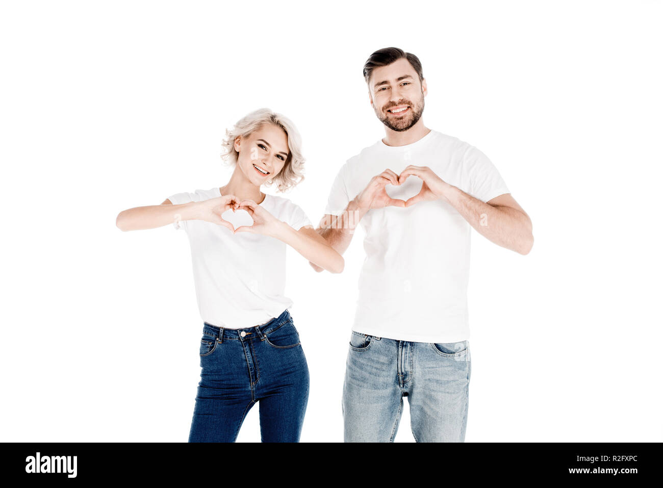 Coppia splendida mostra forma di cuore gesto con le dita amore isolato su bianco Foto Stock