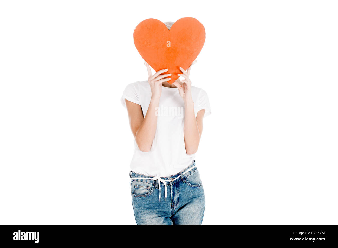 Donna in t-shirt bianco azienda red grande forma di cuore nella parte anteriore della faccia isolato su bianco Foto Stock
