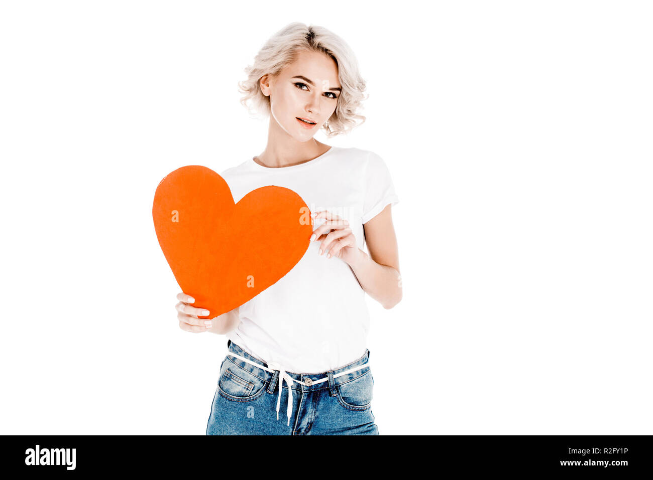 Splendida giovane donna adulta azienda cuore rosso isolato su bianco Foto Stock