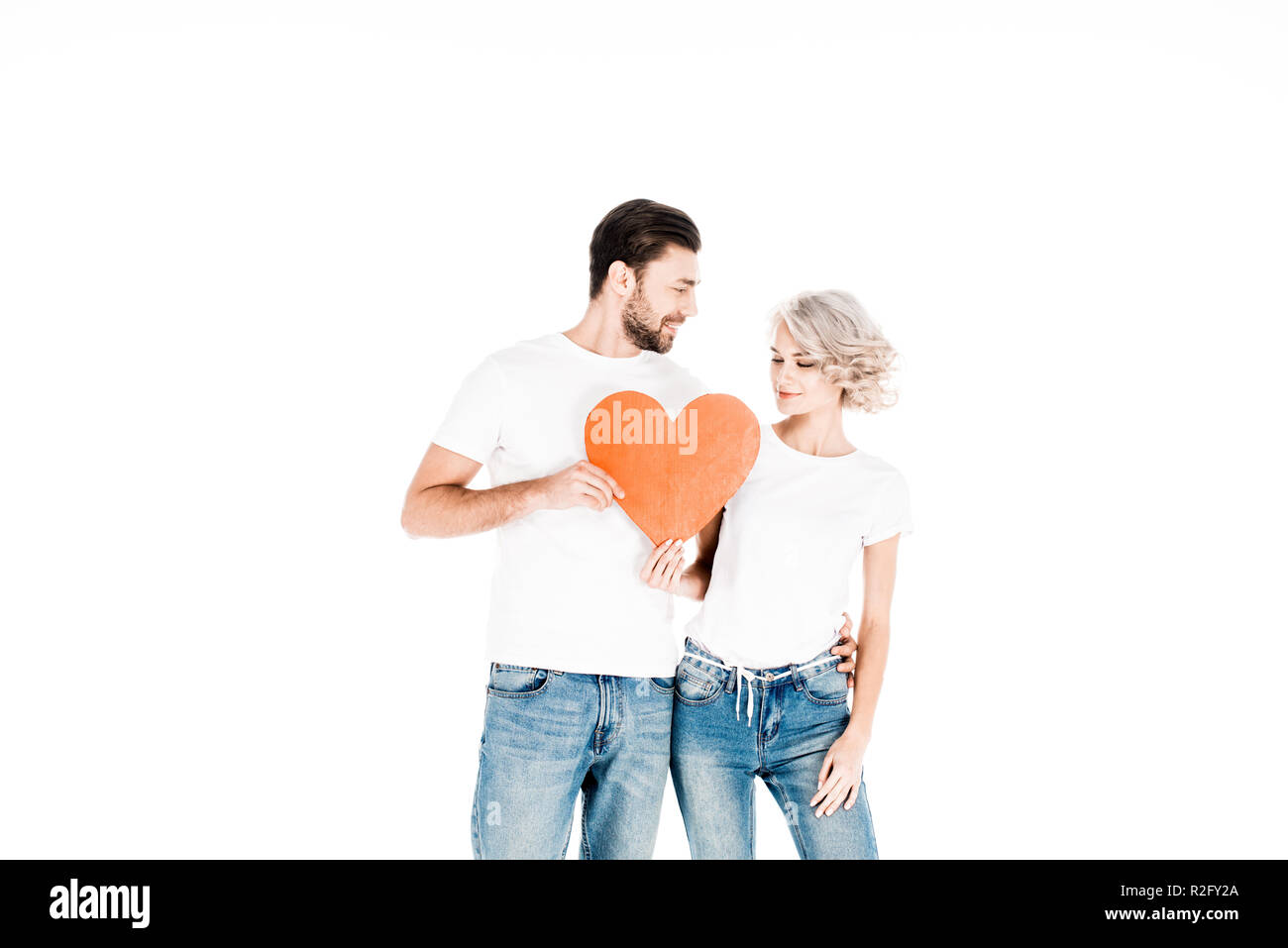 Grande coppia attraente tenendo i segni di amore isolato su bianco Foto Stock