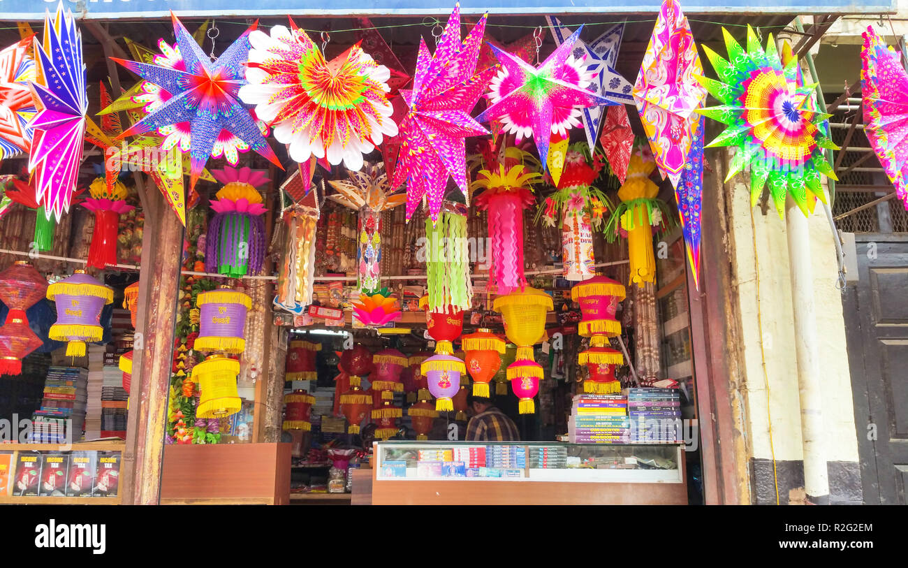 Un artista appeso stelle e lanterna fuori il suo negozio Foto Stock