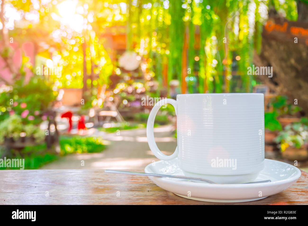 Tazza di caffè sul tavolo di legno verde natura outdoor garden sfondo. Foto Stock