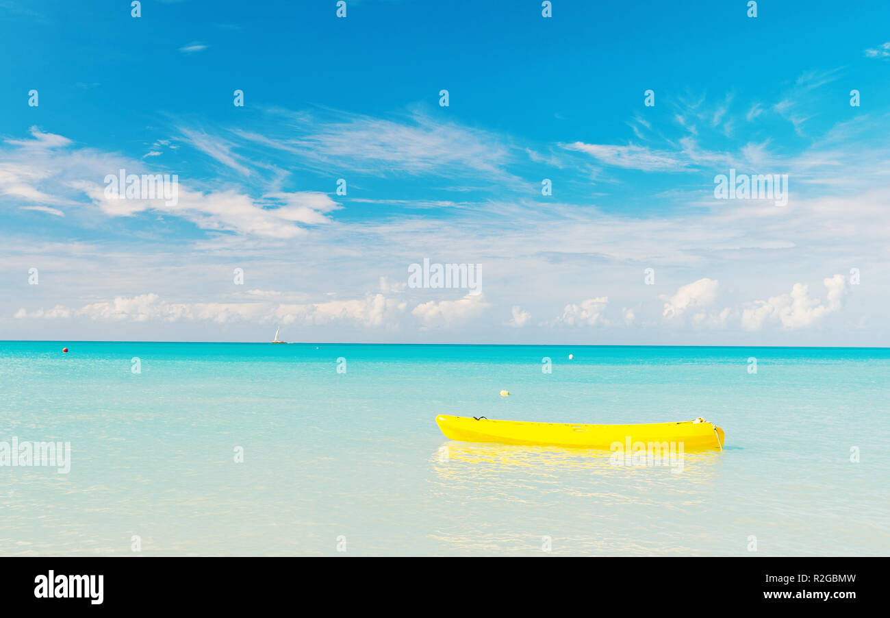 Barca gialla sul mare turchese o acqua oceanica in st Johns, Antigua, sulla giornata di sole sul cielo blu sullo sfondo. Vacanze estive sui Caraibi. Viaggiando, avventura, wanderlust concept Foto Stock