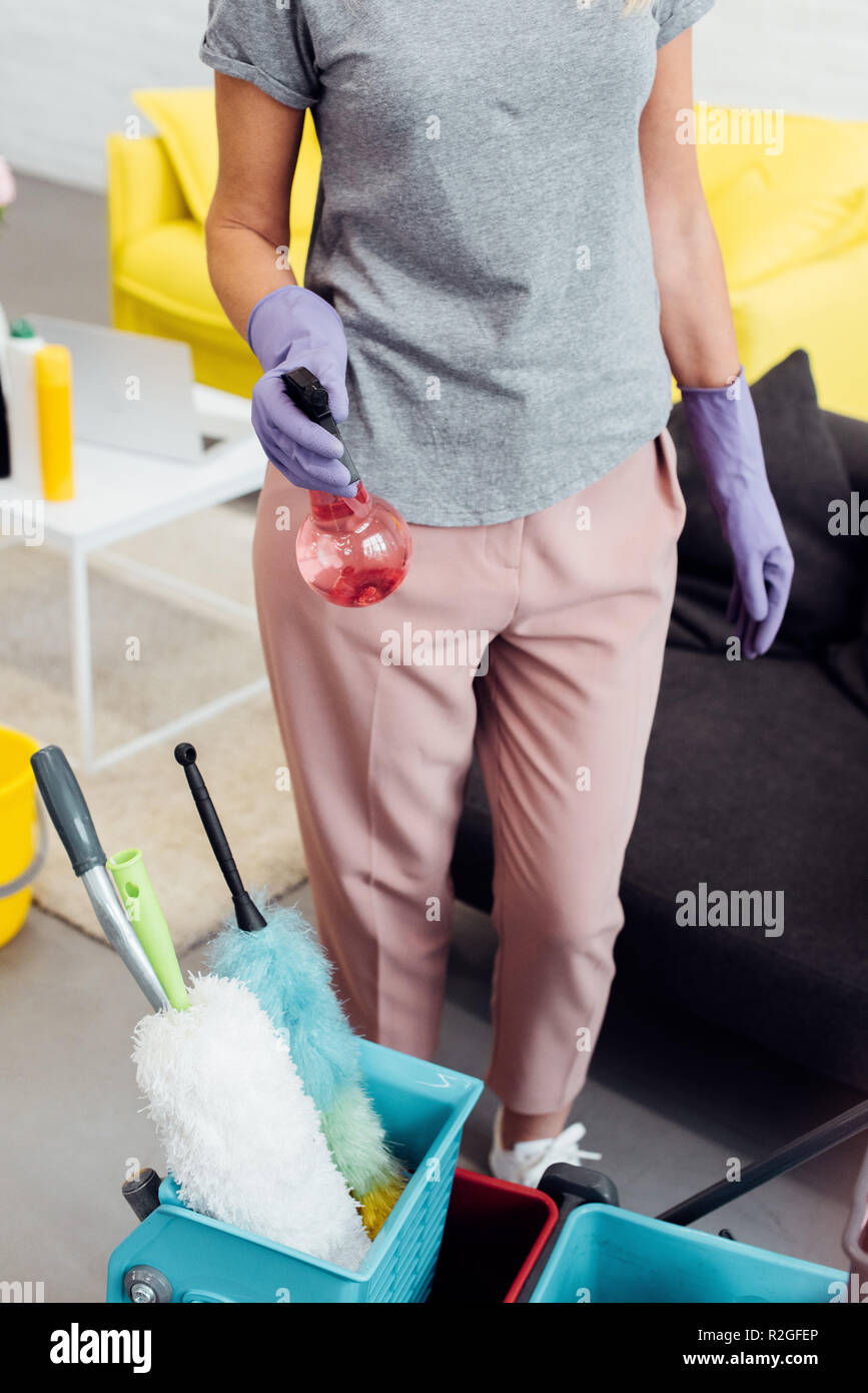Close up della donna nei guanti di gomma con forniture di uso domestico Foto Stock
