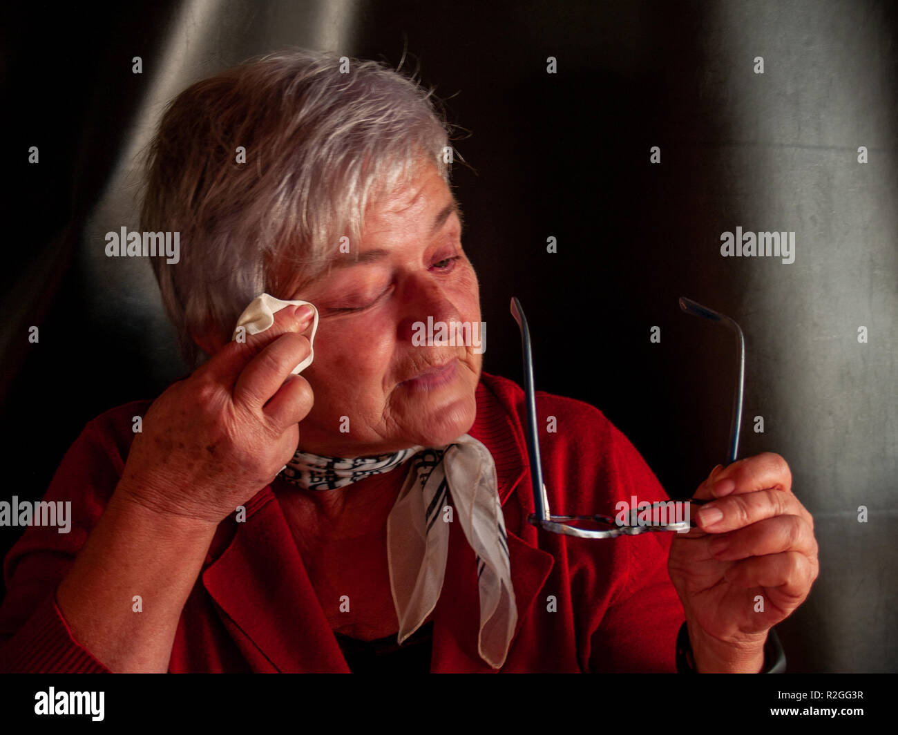 Un senior donna che piange e strofinando le lacrime con un fazzoletto Foto  stock - Alamy