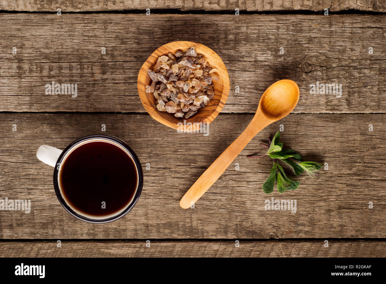 Tazza da tè con foglie di menta e zucchero di canna in ciotola di legno rustico sfondo. Copia dello spazio. Vista superiore Foto Stock
