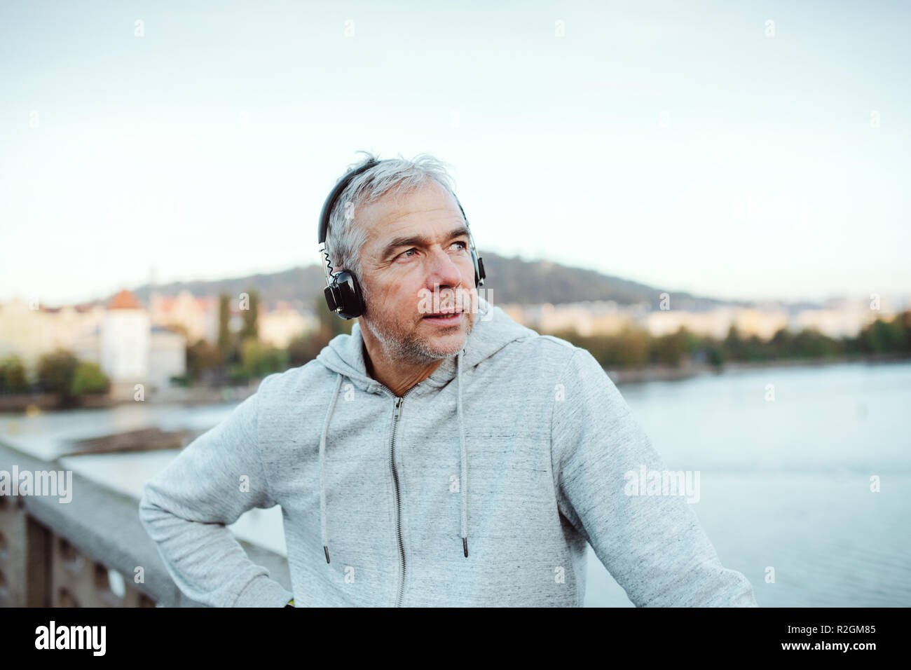 Maschio maturo runner con le cuffie all'aperto in città, l'ascolto di musica. Foto Stock