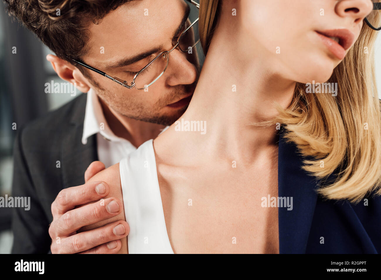 Vista parziale di imprenditore baciare i colleghi collo, ufficio concetto romantico Foto Stock
